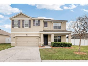 Charming two-story home features a two-car garage, neat landscaping, and shuttered windows at 35691 Jenny Lynne Cir, Zephyrhills, FL 33541