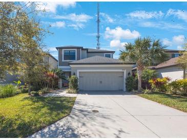 Two-story home featuring a spacious driveway, two-car garage, and landscaping at 8890 Arabella Ln, Seminole, FL 33777