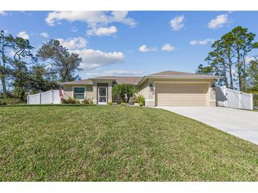 Charming single-story home with a well-manicured lawn and a two-car garage at 1221 Dustin Rd, North Port, FL 34288