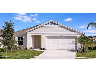 Charming single-story home featuring a two-car garage, well-manicured lawn, and appealing architectural details at 14777 Summer Branch Dr, Lithia, FL 33547