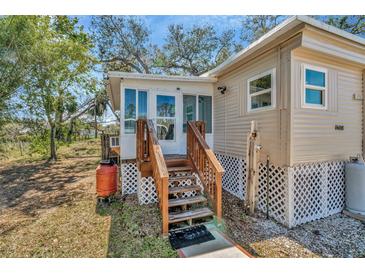 Charming single-story home with a cozy porch and well-maintained landscaping at 1608 Thrush Dr, Zephyrhills, FL 33540