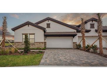 Beautiful single-Gathering home featuring a two-car garage, stone accents, and a paved driveway at 1988 Webbstone Way, Zephyrhills, FL 33541