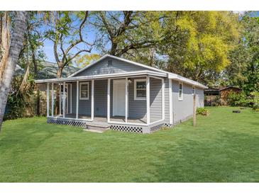 Charming gray home featuring a covered porch and a well-maintained lawn at 9315 N 19Th St, Tampa, FL 33612