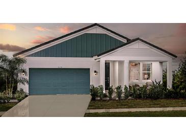 Inviting single Gathering home with a charming entry, blue garage door, and manicured lawn at 10267 Fieldstone Myrtle Way, San Antonio, FL 33576