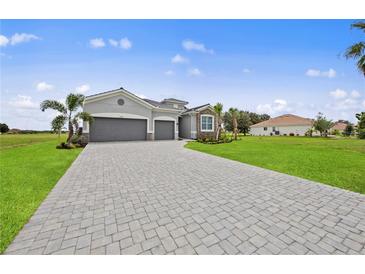 Charming single-story home with a well-manicured lawn and a gray brick driveway leading to a two-car garage at 24041 Peppercorn Rd, Punta Gorda, FL 33955