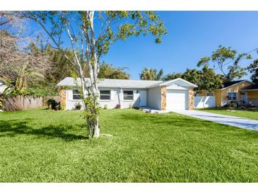 Charming single-story home boasts a well-manicured lawn and a stone-accented facade, creating an inviting curb appeal at 2945 57Th N Ave, St Petersburg, FL 33714