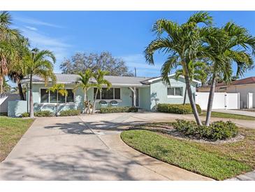Charming single-story home featuring a well-manicured lawn, palm trees, and a spacious driveway at 1003 39Th Ne Ave, St Petersburg, FL 33703