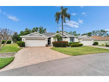 Charming home featuring a well-manicured lawn and a beautiful brick driveway and walkway at 2222 Mayfield Palms Ln # 322, Sun City Center, FL 33573