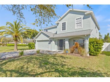 Charming two-story home with a manicured lawn, mature trees, and an attached two-car garage at 2944 Billingham Dr, Land O Lakes, FL 34639