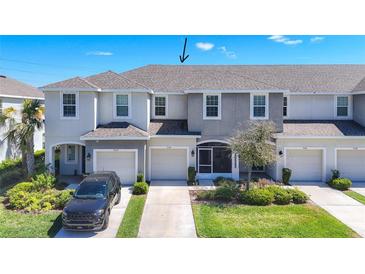 Charming townhome featuring a well-manicured lawn, attached garage, and neutral exterior paint scheme at 7124 Summer Holly Pl, Riverview, FL 33578