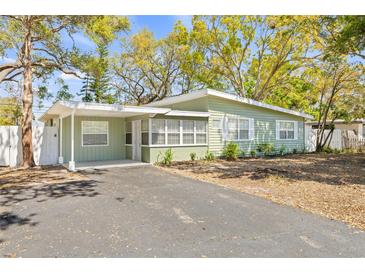 Charming single-story home with a light green exterior, inviting front porch and ample parking on a paved driveway at 7241 12Th N Ave, St Petersburg, FL 33710