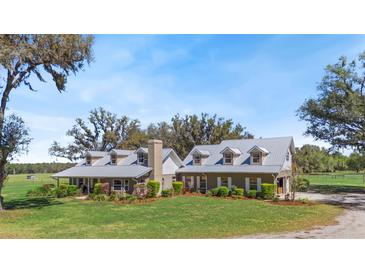 Stunning two-story home featuring metal roof, manicured lawn, and mature trees offering shade and privacy at 808 Old Welcome Rd, Lithia, FL 33547