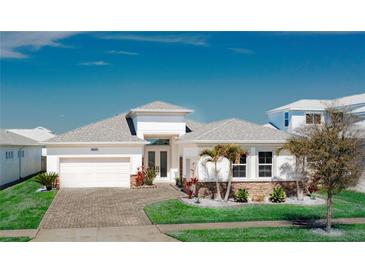 Charming single-story home with a well-manicured lawn, attached garage, and beautiful landscaping at 8261 Ivy Stark Blvd, Wesley Chapel, FL 33545