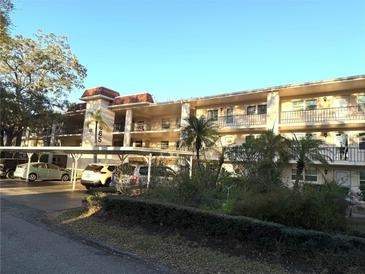 A three-story condo building with covered parking and landscaping features inviting balconies at 865 Virginia Ct # 106, Dunedin, FL 34698