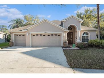Charming single-story home with a manicured lawn and a two-car garage, perfect for families at 10623 Pearl Berry Loop, Land O Lakes, FL 34638
