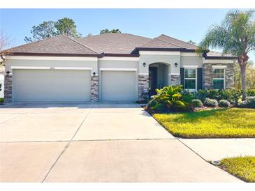 Charming one-story home featuring a three-car garage and beautifully landscaped front yard at 12403 Brick Cobblestone Dr, Riverview, FL 33579