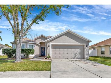Charming single-story home with a two-car garage, well-manicured lawn, and mature shade tree in the front yard at 3412 Trapnell Ridge Dr, Plant City, FL 33567