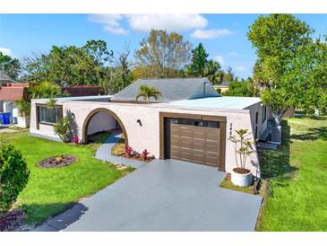 Charming single-story home with a gray driveway and a well-manicured front lawn at 3455 Overland Dr, Holiday, FL 34691