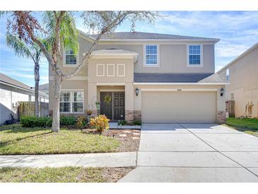 Charming two-story home featuring a well-manicured front yard and a two-car garage at 5916 Tulip Flower Dr, Riverview, FL 33578