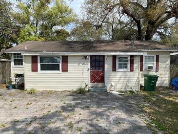 Cozy single story home with brick-paved driveway, neutral siding, and traditional-style windows at 8405 N Willow Ave, Tampa, FL 33604