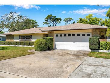 Charming single story home with stone accents, manicured lawn, and an attached two car garage at 106 Indian Rocks S Rd, Belleair Bluffs, FL 33770