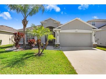 Charming single-story home with well-manicured lawn, landscaping, and attached two-car garage at 15414 Fire Rock Pl, Ruskin, FL 33573
