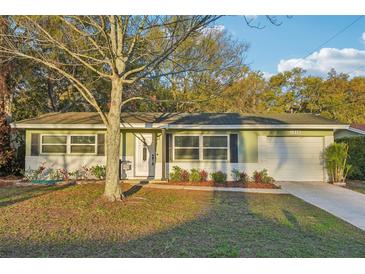 Charming single-story home with well-maintained lawn, garden beds, and attached one-car garage at 1828 Barbara Ln, Clearwater, FL 33755