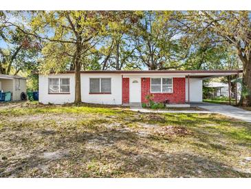 Charming single-story home with red brick accents, a covered parking area, and a well-maintained front yard at 3005 E Sligh Ave, Tampa, FL 33610