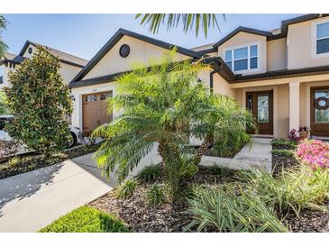 Charming townhome featuring a well-manicured lawn and welcoming entryway at 30903 Quail Caper Cir, San Antonio, FL 33576