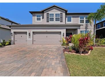 Charming two-story home featuring a three-car garage and beautifully landscaped front yard at 4923 Eagle Rock Dr, Wimauma, FL 33598