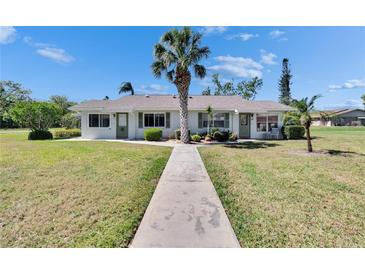 Charming single-story home with a well-maintained lawn, mature landscaping, and a welcoming walkway leading to the front door at 1902 Dandridge St # 6, Sun City Center, FL 33573