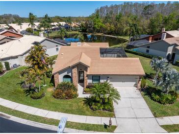 Beautiful home with mature landscaping, tile roof, and pond view at 3639 Darston St, Palm Harbor, FL 34685