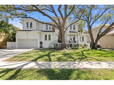 Charming two-story home with mature trees, beautiful landscaping, and a two-car garage at 4614 W Lowell Ave, Tampa, FL 33629