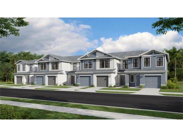 View of newly constructed townhomes with two stories, garages, and well-maintained landscaping at 14110 Lilac Sky Ter, Bradenton, FL 34211