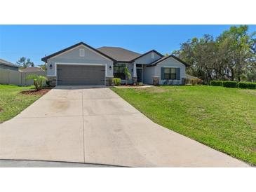 Beautiful one-story home with a well-manicured lawn, long driveway, and a two-car garage at 32510 Southfield Ct, Dade City, FL 33525