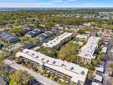 Expansive aerial view of community featuring mature trees, several condo buildings and community pool at 11700 Park Blvd # 202, Seminole, FL 33772