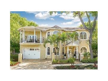 Elegant two-story home features a balcony, arched windows, and a well-maintained front yard at 2308 W Jetton Ave, Tampa, FL 33629