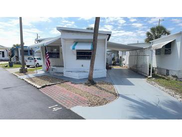 Charming mobile home with awnings, an American flag and a driveway at 4851 W Gandy Blvd # B1L14, Tampa, FL 33611