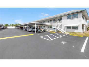 Exterior of condo building with parking lot including covered parking spaces for residents and guests at 5347 81St N Ln # 25, St Petersburg, FL 33709