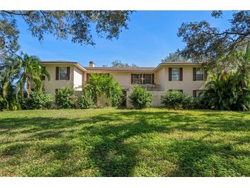 Charming two-story home with lush green lawn and mature landscaping at 11327 Carter Grove Ln, Thonotosassa, FL 33592