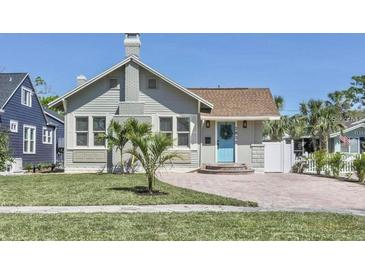 Charming bungalow-style home with a brick driveway, well-manicured lawn, and inviting light blue front door at 2835 3Rd N Ave, St Petersburg, FL 33713