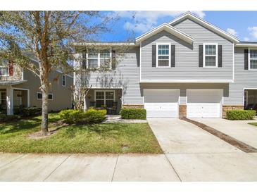 Charming townhouse featuring a two-car garage, well-maintained lawn, and inviting curb appeal at 3002 Mojave Oak Dr, Valrico, FL 33594