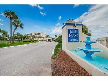 Gulf Island Beach and Tennis Club entrance with lush landscaping, blue fountain and palm trees at 6009 Sea Ranch Dr # 206, Hudson, FL 34667