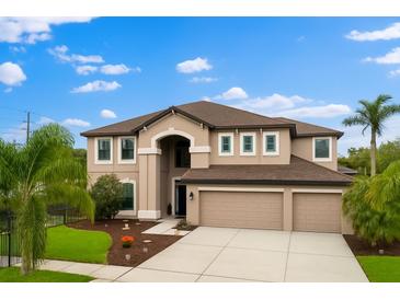 Beautiful two-story home with a three-car garage, manicured lawn, and lovely landscaping at 9402 59Th N St, Pinellas Park, FL 33782