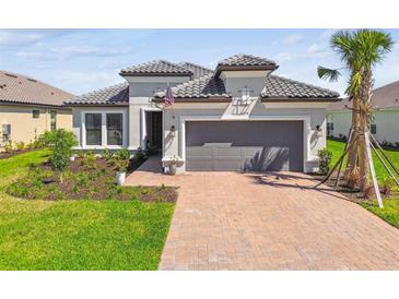 Charming single-story home with a tile roof, brick driveway, and well-maintained landscaping at 4574 Freccia Loop, Wesley Chapel, FL 33543
