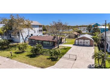 Charming single-story home with a gated entrance, well-manicured lawn, and unique garage at 5560 Frances Ave, New Port Richey, FL 34653