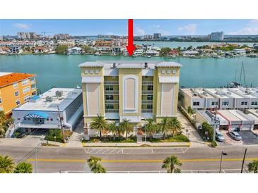 Beautiful condominium building with a view of the water and palm trees at 706 Bayway Blvd # 301, Clearwater Beach, FL 33767
