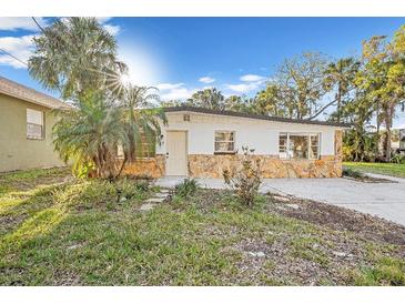 Charming single-story home featuring a stone facade and a well-maintained front yard with a palm tree at 7301 S Swoope St, Tampa, FL 33616