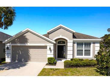 Charming single-story home featuring a 2-car garage, manicured lawn, and neutral-toned exterior at 7326 Blue Beech Dr, Riverview, FL 33578