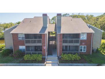 Brick exterior of two-story condo with screened balconies and manicured landscaping in a waterfront community at 9100 Dr Martin Luther King Jr N St # 405, St Petersburg, FL 33702